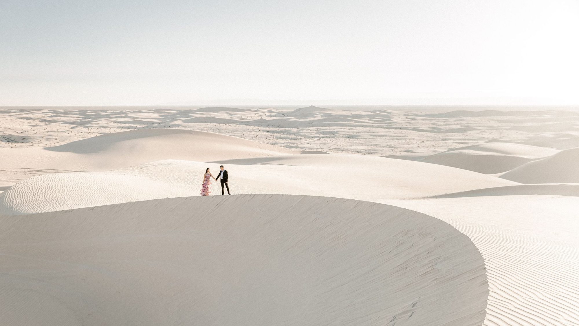 Walking the dunes, her red dress catching the wind