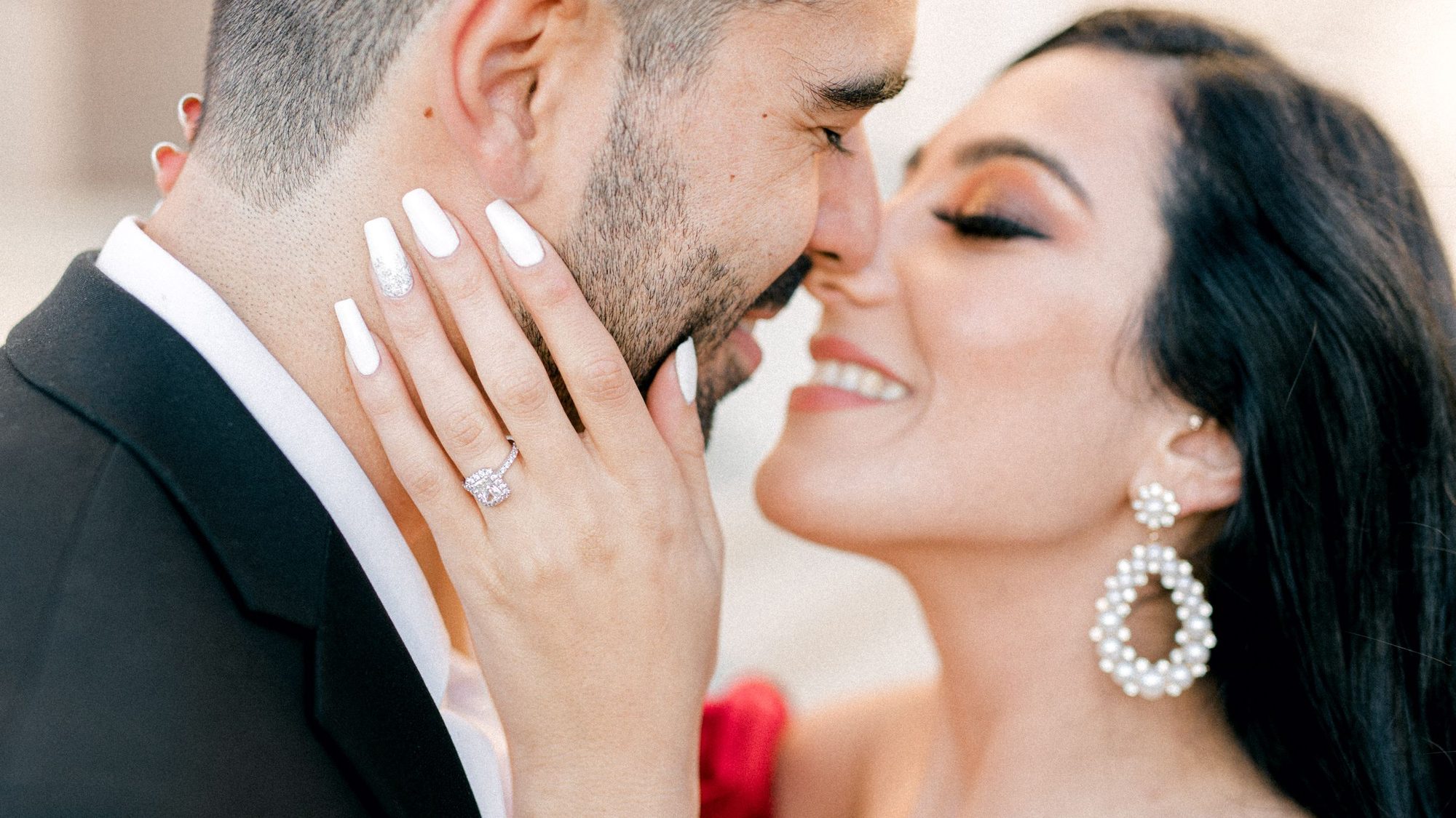 Close up, her engagement ring on his cheek