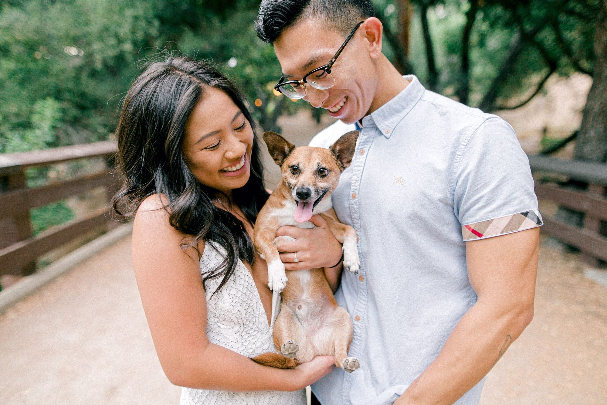 Couple laughing while holding their dog