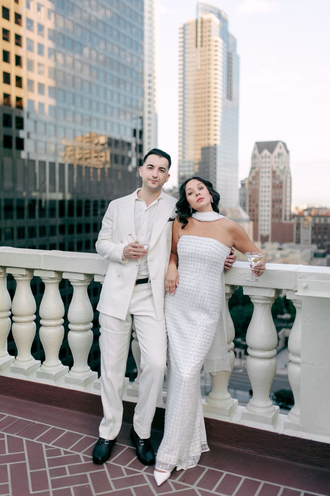 Couple on a balcony with city towers behind