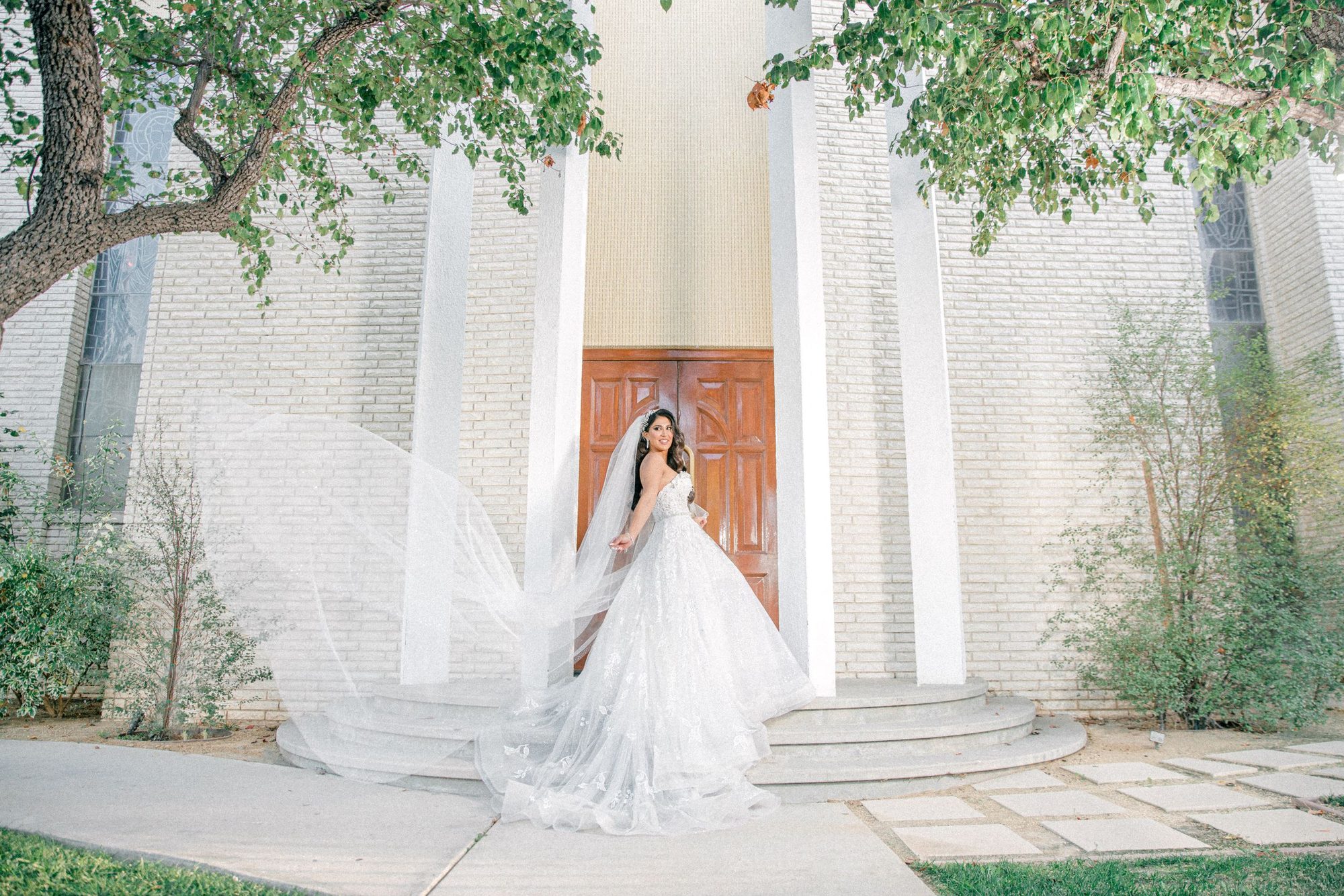 Bride at the chapel doors, veil in the wind