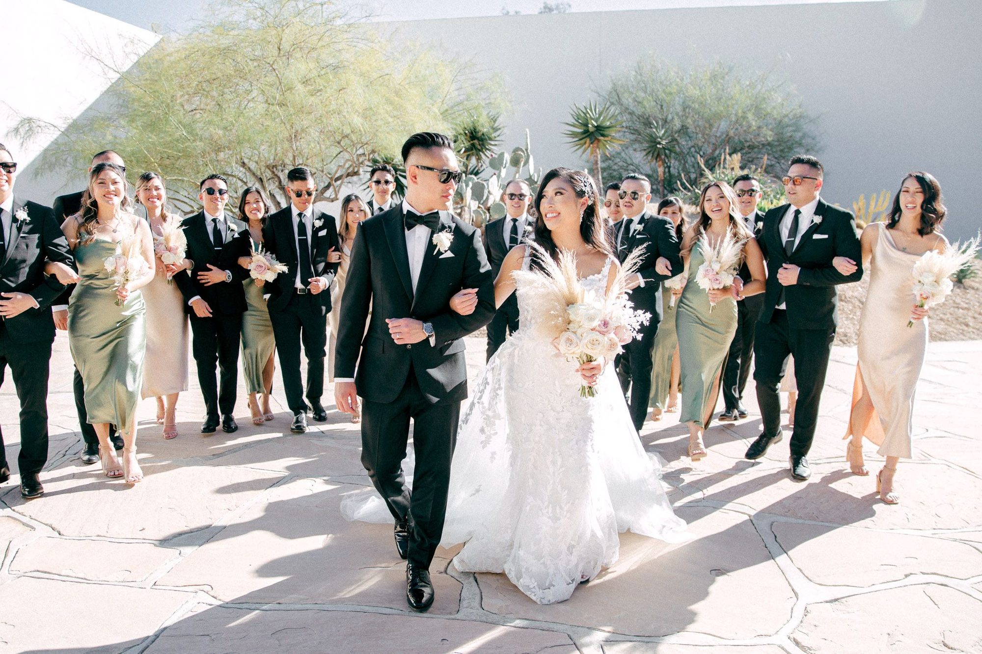 Bridal party walking through a sunny courtyard