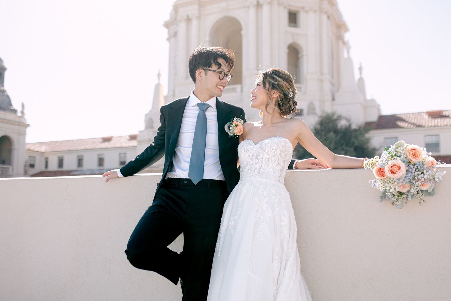 Couple leaning on a balustrade in front of a white domed tower