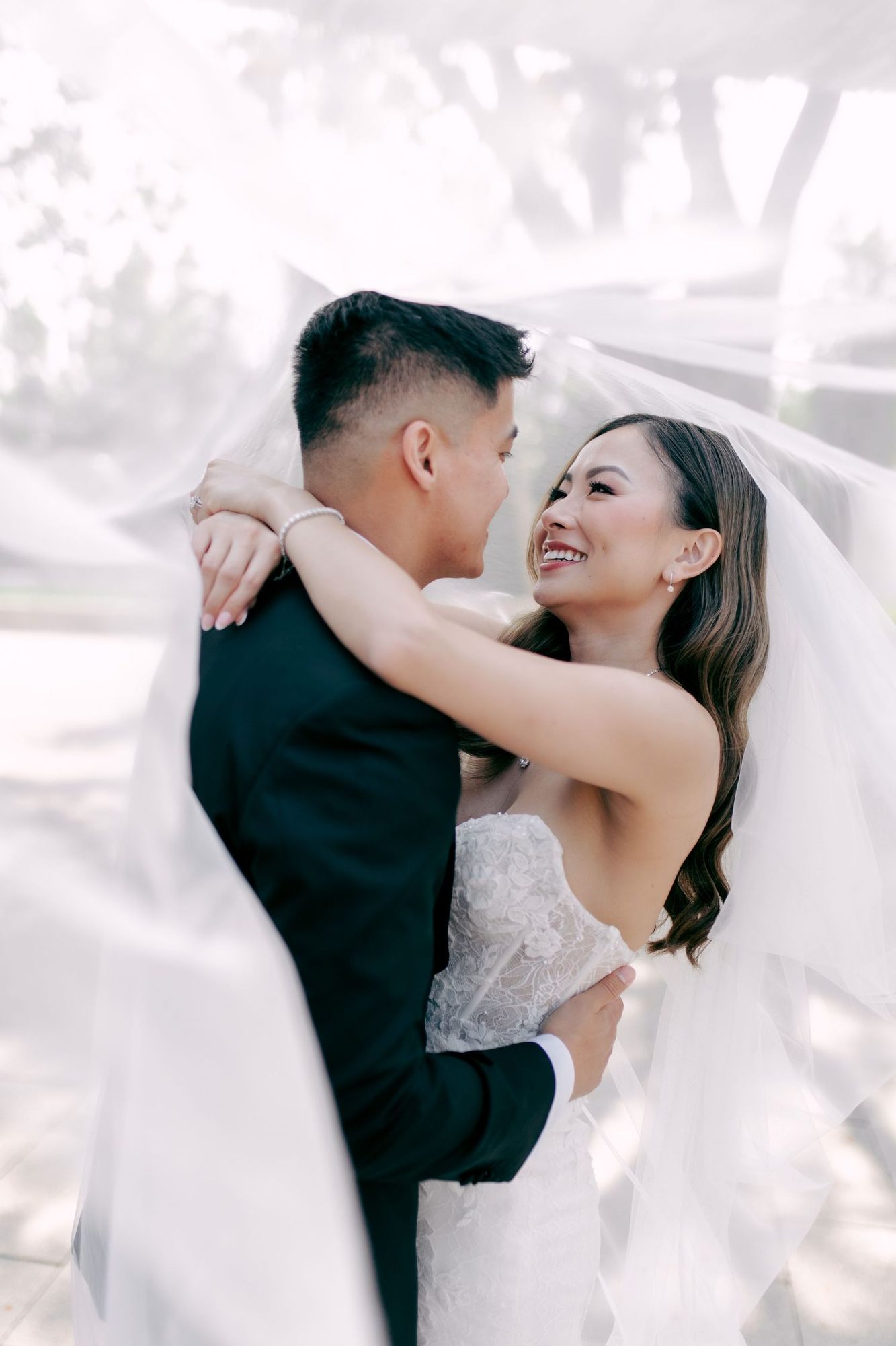 Couple hugging under a blowing veil, portrait
