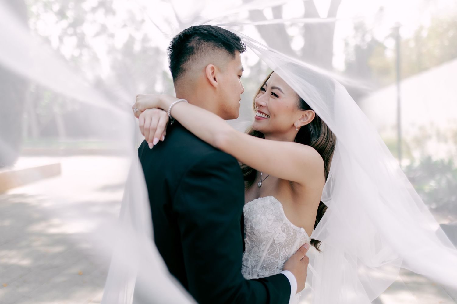 Couple hugging under a blowing veil