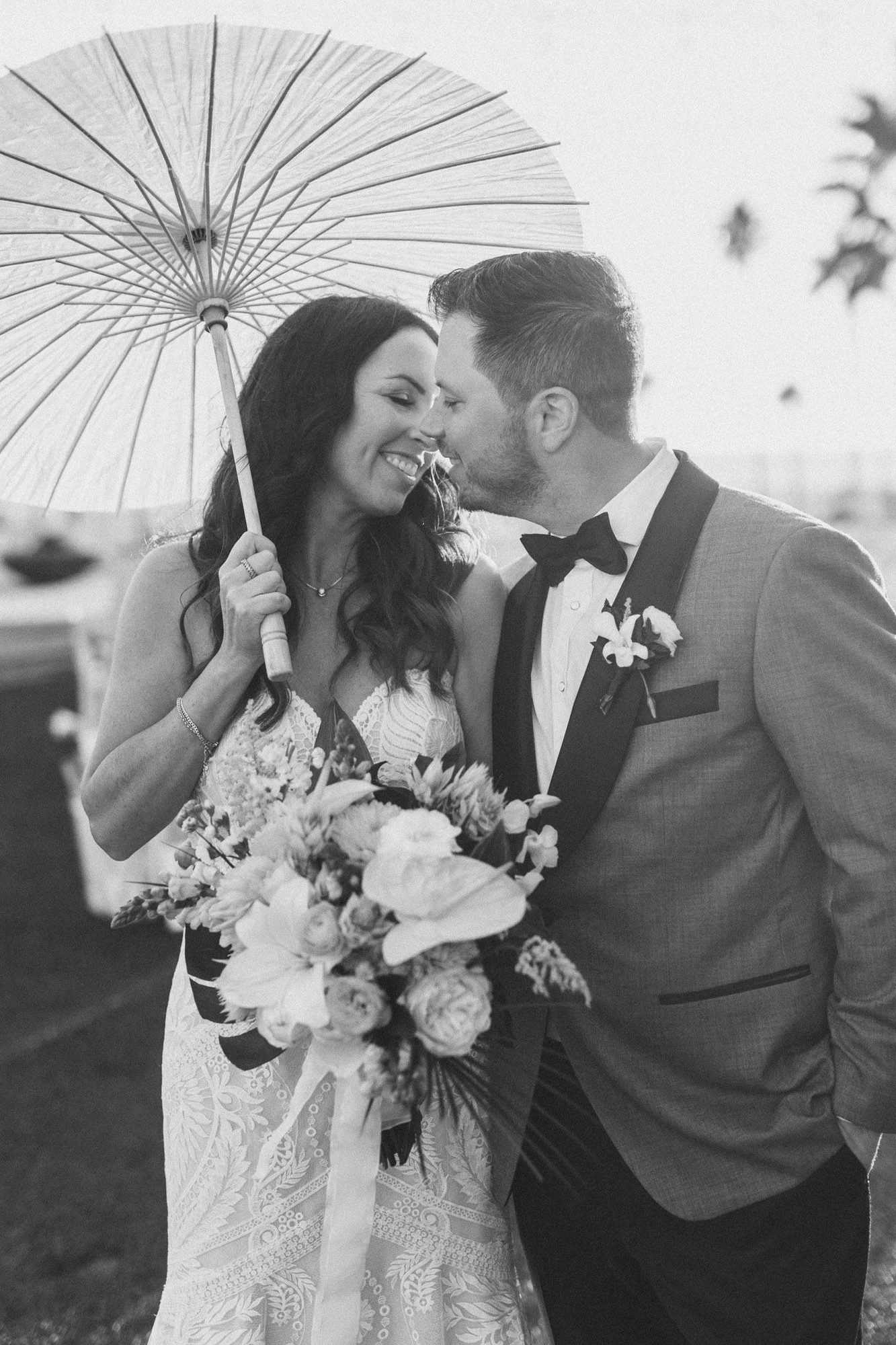 Black and white portrait of a couple under a paper parasol